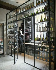 a woman standing in front of a display case filled with bottles