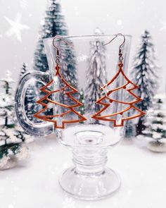 a glass mug with christmas trees in it