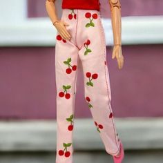 the doll is wearing pink pajamas with cherries on it's pants and shoes