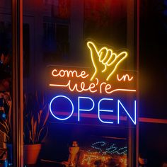 a neon sign that says come in we're open