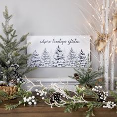 christmas trees and pine cones are arranged on the mantle