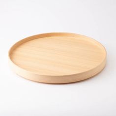 a round wooden tray on a white background