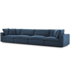 a blue sectional couch with pillows on the top and bottom, in front of a white background