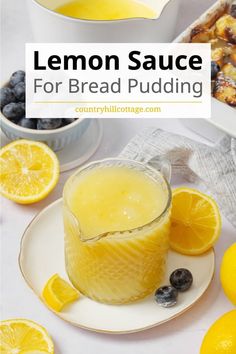 lemon sauce for bread pudding with blueberries and lemons on the side, next to a glass of orange juice