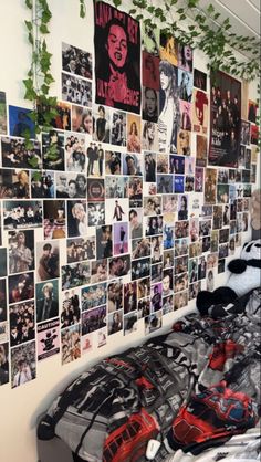 a room with many pictures on the wall and plants growing over the bedspread