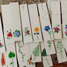 several cards with flowers are hanging on a string next to some thread and twine