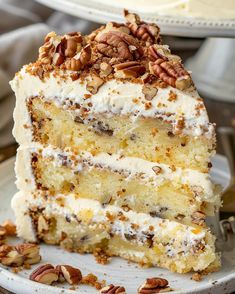 a piece of cake with pecans on top is sitting on a plate next to the rest of the cake