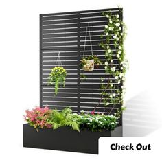 an outdoor planter with flowers and plants growing on it