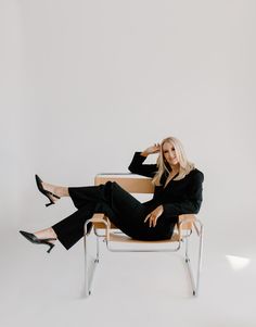 a woman sitting in a chair with her legs crossed