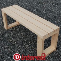 a wooden bench sitting on top of a gravel covered ground with the word interest written below it