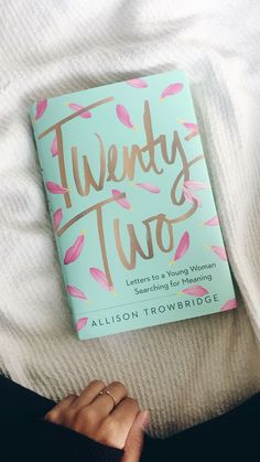 the book twenty two by allison troubridgee is laying on top of a bed