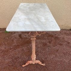 a white table sitting on top of dirt covered ground