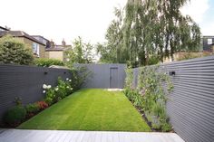 a backyard with grass, flowers and trees