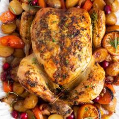 roasted chicken with potatoes, carrots and cranberries on a white platter