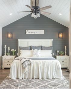 a white bed sitting under a ceiling fan in a bedroom next to a wooden floor