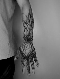 black and white photograph of a person's hand with spider web on the palm