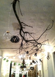 Gold winter toned holiday party featuring suspended branches, clear bulbs and paper ornaments.