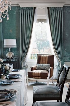 an elegant dining room with green walls and curtains