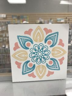 a card with an image of a colorful flower on it in a store display window