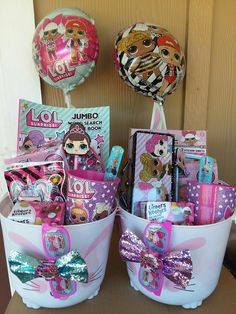 two baskets filled with toys and balloons on top of a wooden table in front of a door