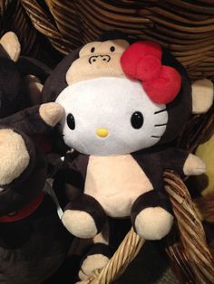 two hello kitty stuffed animals sitting next to each other in a wicker hamper