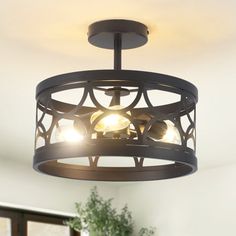 a light fixture in a living room with a potted plant on the table next to it