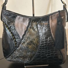 Beautiful Black Sharif Shoulder Bag. Mrp $300.00 Interior Is All Leather And In Perfect Condition. This Bag Looks Brand New. Ostrich Embossed On Both Sides And Bottom. Blends Of Snake And Alligator Designs With Golds Running Through The Color. Excellent Condition. Great Everyday, Sturdy Bag. Clean No Rips Or Orders. Very Classic Mid Sized Bag With A Zipper Closure. Interior Pocket With Zipper. Clean Looks New. No Odors Or Questions? Leave A Comment Below! Designer Black Shoulder Bag With Crocodile Pattern, Black Leather Bag With Crocodile Pattern, Elegant Black Hobo Bag With Leather Backing, Elegant Black Leather Hobo Bag, Black Textured Leather Rectangular Hobo Bag, Black Rectangular Textured Leather Hobo Bag, Emboss, Alligator, Bag Lady