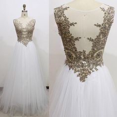 a white and gold wedding dress with sheer tulle, beaded detailing on the back