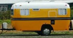 an orange and white trailer parked in front of a house