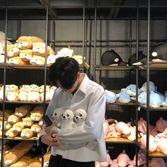 a person standing in front of shelves with stuffed animals