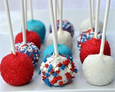 red, white and blue cake pops with sprinkles are on a plate