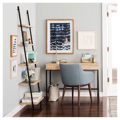 a desk and chair in a room with pictures on the wall above it, next to a ladder