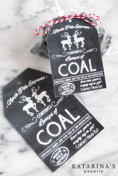 two bags of coal sitting on top of a marble counter next to a bag of candy