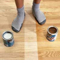 someone is standing on the floor with their feet up next to two cans of paint