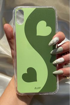 a woman's hand holding a green and white phone case with the letter s on it