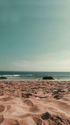 a surfboard sitting on top of a sandy beach