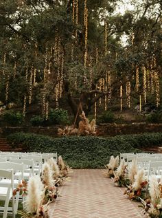 an outdoor ceremony setup with white chairs and flowers