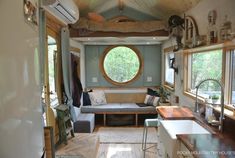 the inside of a tiny home with a couch and kitchenette in it, as well as a living room