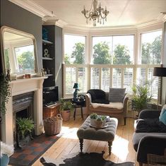 a living room filled with furniture and a fire place in front of a window covered in blinds