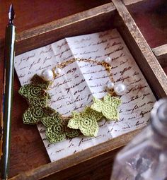 a close up of a box with a necklace on it and a pen next to it