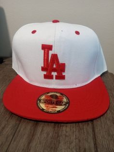 New white and red LA 6 panel snapback Red Hip Hop Fitted Hat For Streetwear, Red Snapback Hat For Streetwear, Red Hip Hop Style Baseball Cap For Sports, Red Fitted Cap For Streetwear, Red Flat Bill Snapback Hat For Streetwear, Red Sporty Snapback Hat For Streetwear, Red Hip Hop Snapback Hat, Sporty Red Snapback Hat For Streetwear, Red Six-panel Fitted Hat For Sports Events