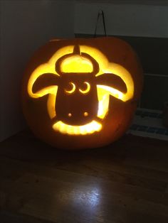 a pumpkin carved to look like a cow with its head cut out in the center