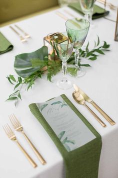 the table is set with green and gold place settings