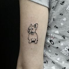 a small dog tattoo on the left arm