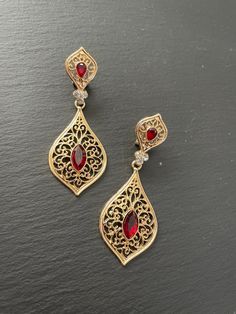 These are lovely dangling chandelier style earrings in gold .an vintage style gold  teardrop dangle earrings with garnet red stones in the middle  These are an Indian earrings that could be worn by both traditional and an western attire. Note: The product shipped will be same as shown in the picture however, actual colours may vary slightly from those shown due to lighting in the photography. Pls note The shades of gold / silver  may vary slightly. We do not accept any returns or refunds.However in case of any issue we will definitely try and resolve it! Red Earrings Indian, Gold Bohemian Crystal Earrings For Wedding, Bohemian Gold Crystal Wedding Earrings, Elegant Teardrop Festival Jewelry, Bohemian Drop Jewelry For Wedding, Jeweled Gold-plated Drop Earrings, Vintage Jeweled Drop Earrings, Bohemian Metal Drop Bridal Earrings, Ornate Teardrop Jewelry With Matching Earrings