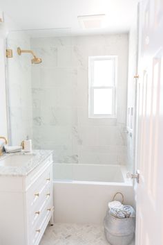 a white bathroom with marble floors and walls