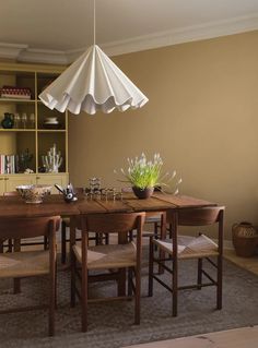 a dining room table with chairs and an umbrella over it's head hanging from the ceiling