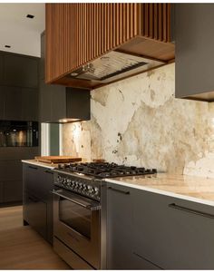 a kitchen with marble counter tops and stainless steel appliances, along with an oven in the center