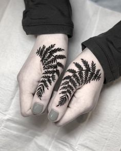 two hands with black leaves on them