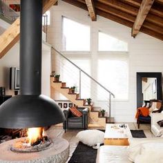 a woman sitting on the floor next to a fire place in a living room filled with furniture